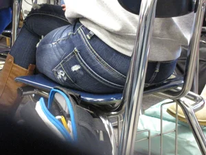Booty in Tight Blue Jeans and Crossed Legs Under Classroom Desk