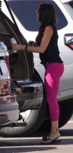 Milf brunette in purplish-pink leggings looking sexy in the parking lot