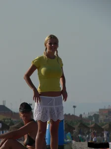 Blonde on the beach topless with big boobs and in a black thong