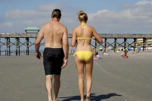 Skinny cute blonde on the beach in yellow bikini