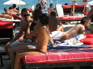 Topless cutie at the beach with a tight little ass in a thong