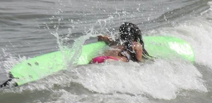 Brunette bikini girl on the beach and surfing in her bikini
